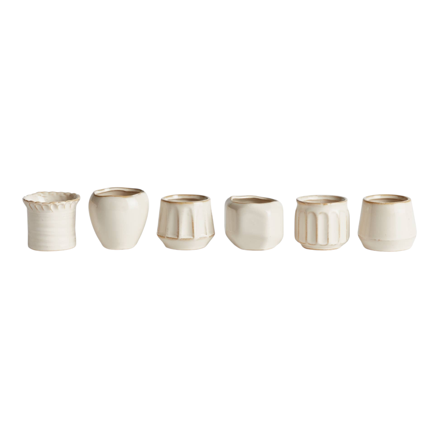 The Tiny Finch Dezie mini pots in a set of six, featuring various cream-colored ceramic shapes and textures.