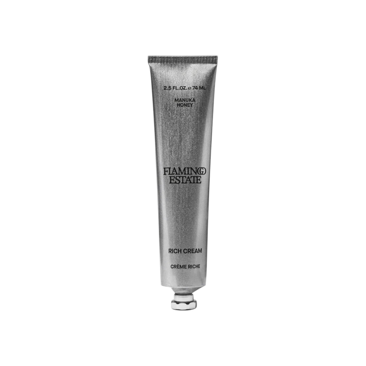 The Tiny Finch Flamingo Estate Manuka Honey Rich Cream in a silver metal tube with award badges on the side.