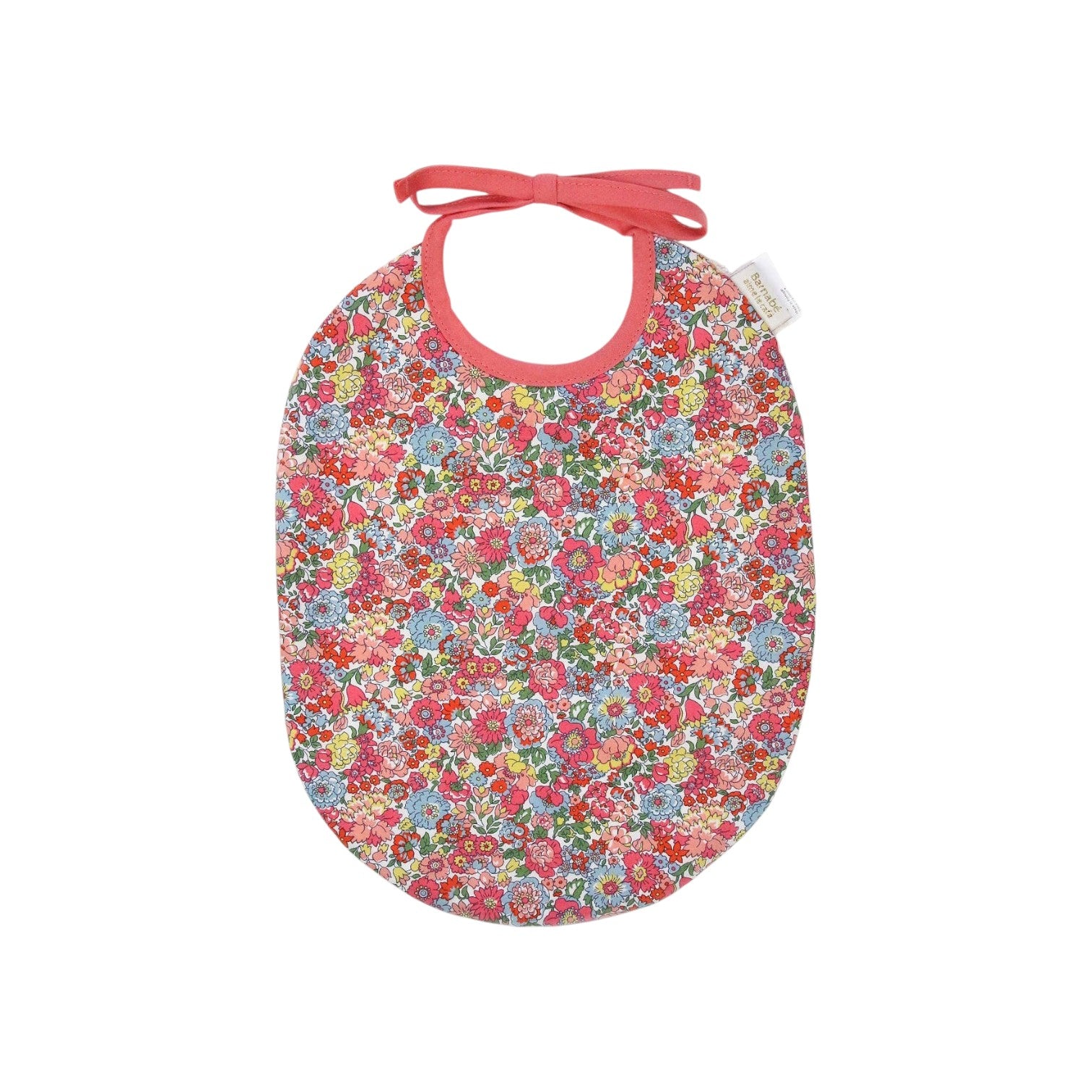 The Tiny Finch Bib Augustine featuring a colorful floral Liberty London cotton print with pink trim and tie closure.