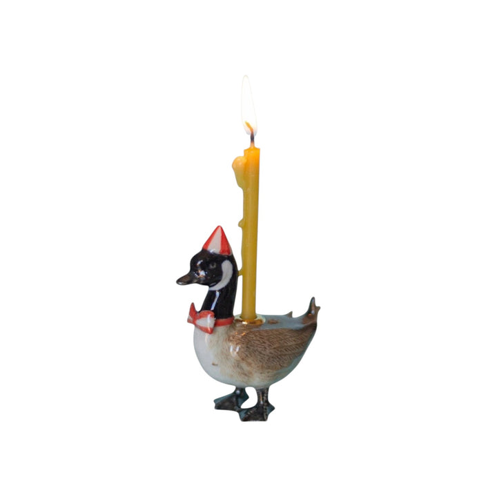 The Tiny Finch Canadian goose cake topper wearing a party hat and bow tie with a lit yellow candle on its back.