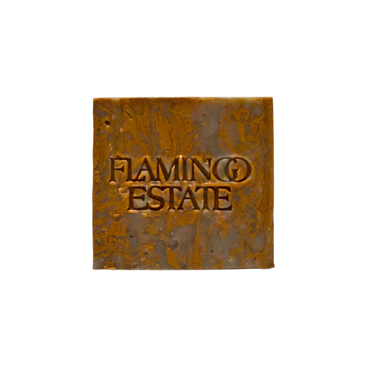 The Tiny Finch Green Goddess soap brick with a marbled brown and gold texture and embossed Flamingo Estate logo.