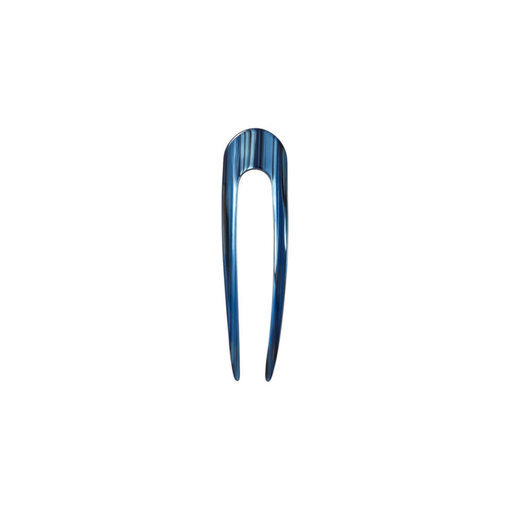 The Tiny Finch French hair pin in indigo blue, handcrafted from polished Italian acetate with a sleek U-shape design.
