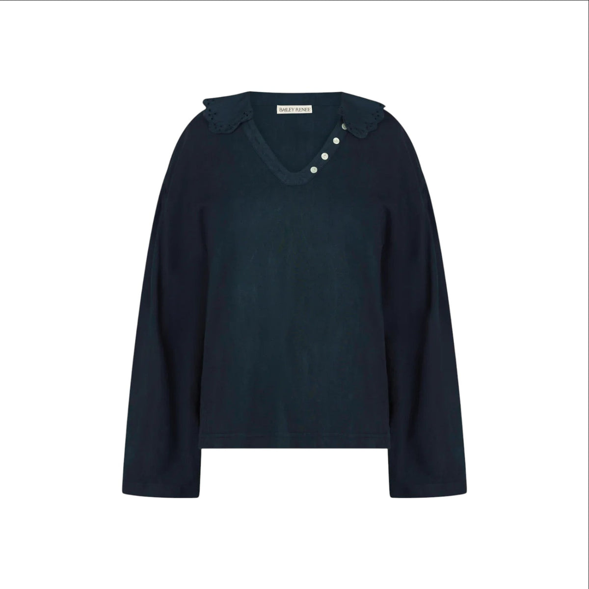 The Tiny Finch Gaia top in indigo cotton featuring a scalloped embroidered collar, V-neck, and mother-of-pearl buttons.