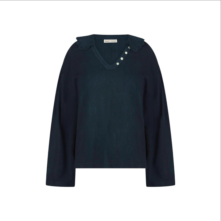 The Tiny Finch Gaia top in indigo cotton featuring a scalloped embroidered collar, V-neck, and mother-of-pearl buttons.