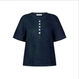 The Tiny Finch indigo henley top with fluttering raglan sleeves, pintuck details, and mother-of-pearl buttons.
