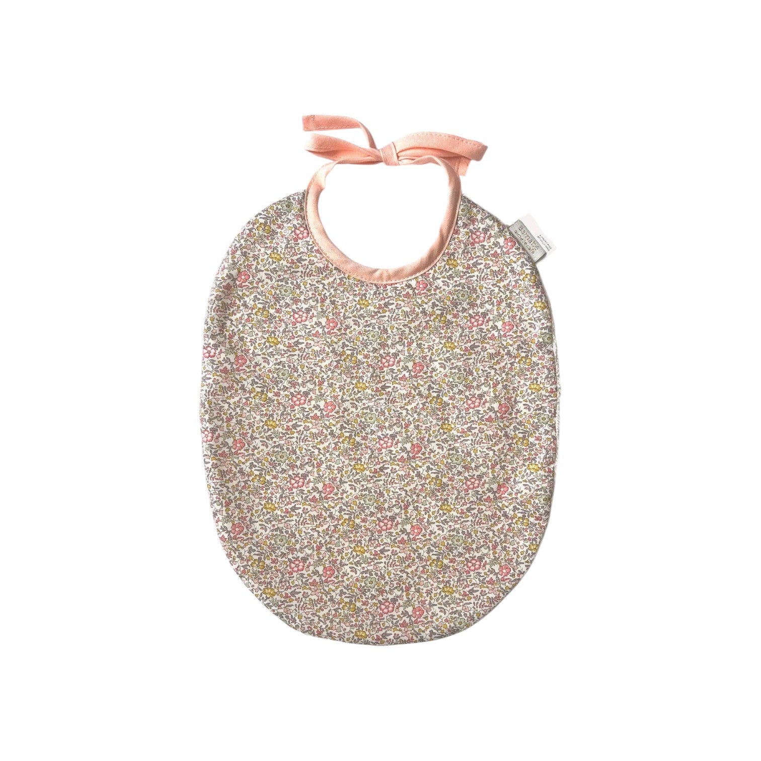 The Tiny Finch Juliette baby bib featuring a delicate floral Liberty fabric print with soft pink ribbon ties.
