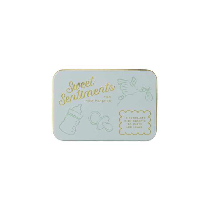The Tiny Finch Sweet Sentiments keepsake tin in light blue with gold-pressed baby-themed illustrations and text.