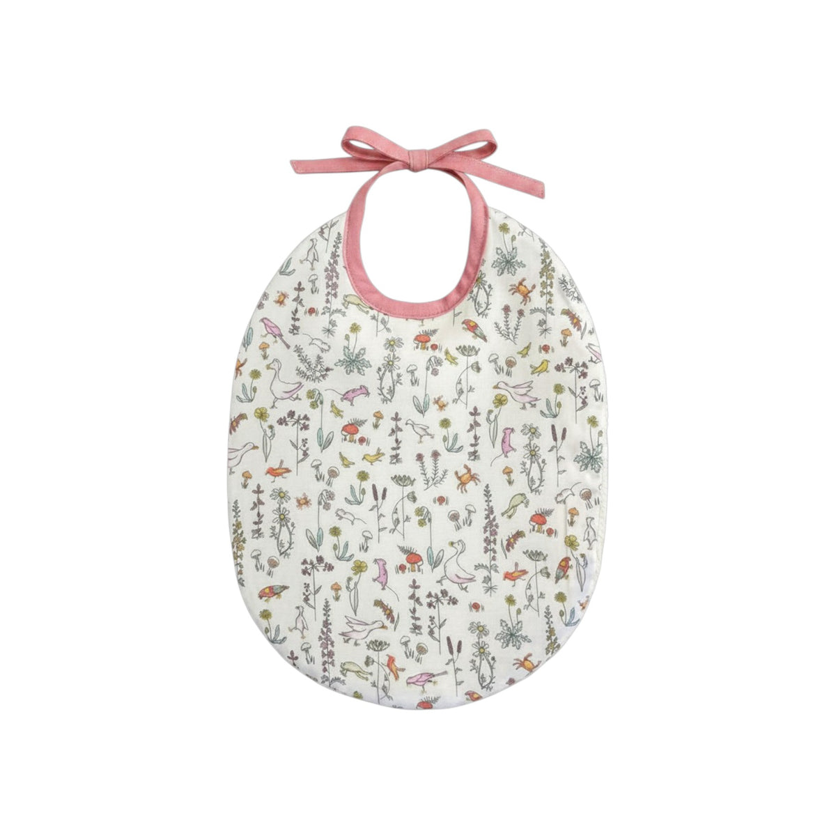 The Tiny Finch Bib Céleste featuring a delicate Liberty floral print on cotton with pink ribbon tie closure.