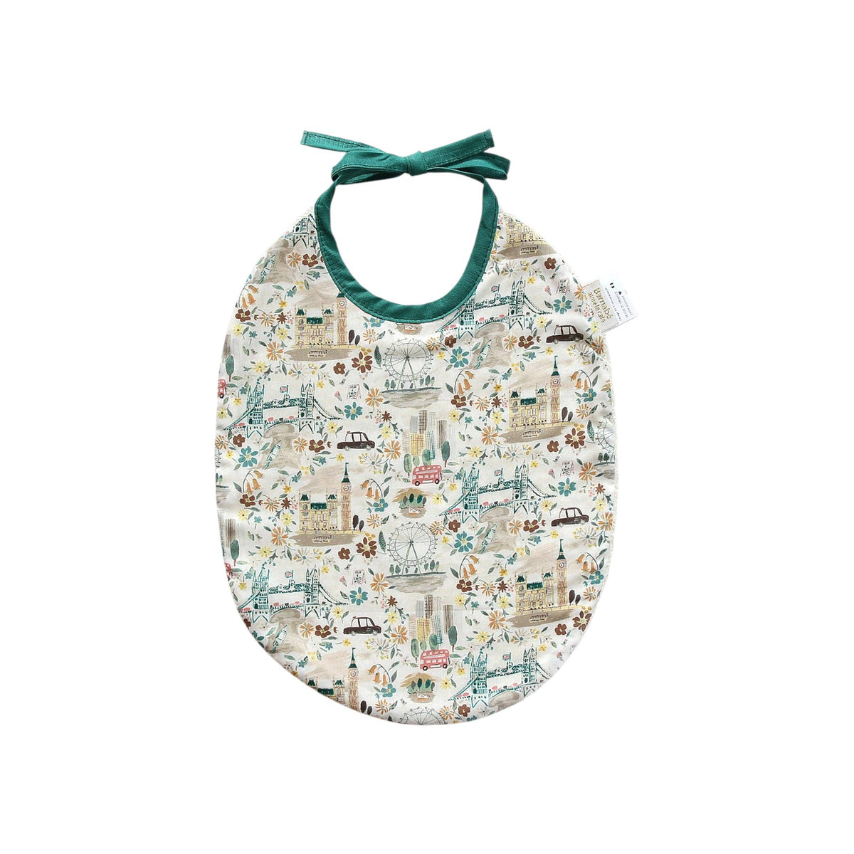 The Tiny Finch Bib John featuring a London-themed Liberty fabric print with green tie straps and absorbent sponge back.