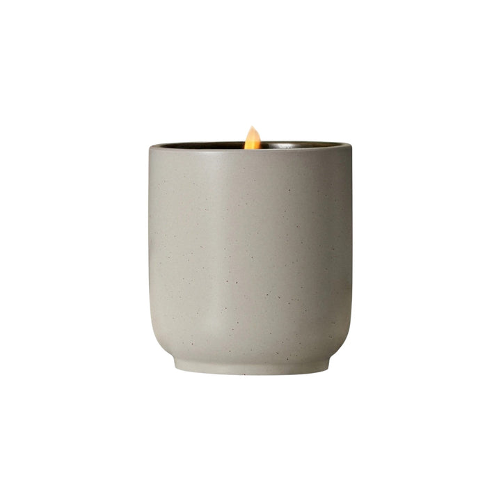 The Tiny Finch Mandarin Basile soy wax candle in a speckled grey kiln-fired ceramic vessel with a lit cotton wick.