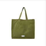 The Tiny Finch moss green organic cotton canvas tote bag with a spacious design and interior pocket.