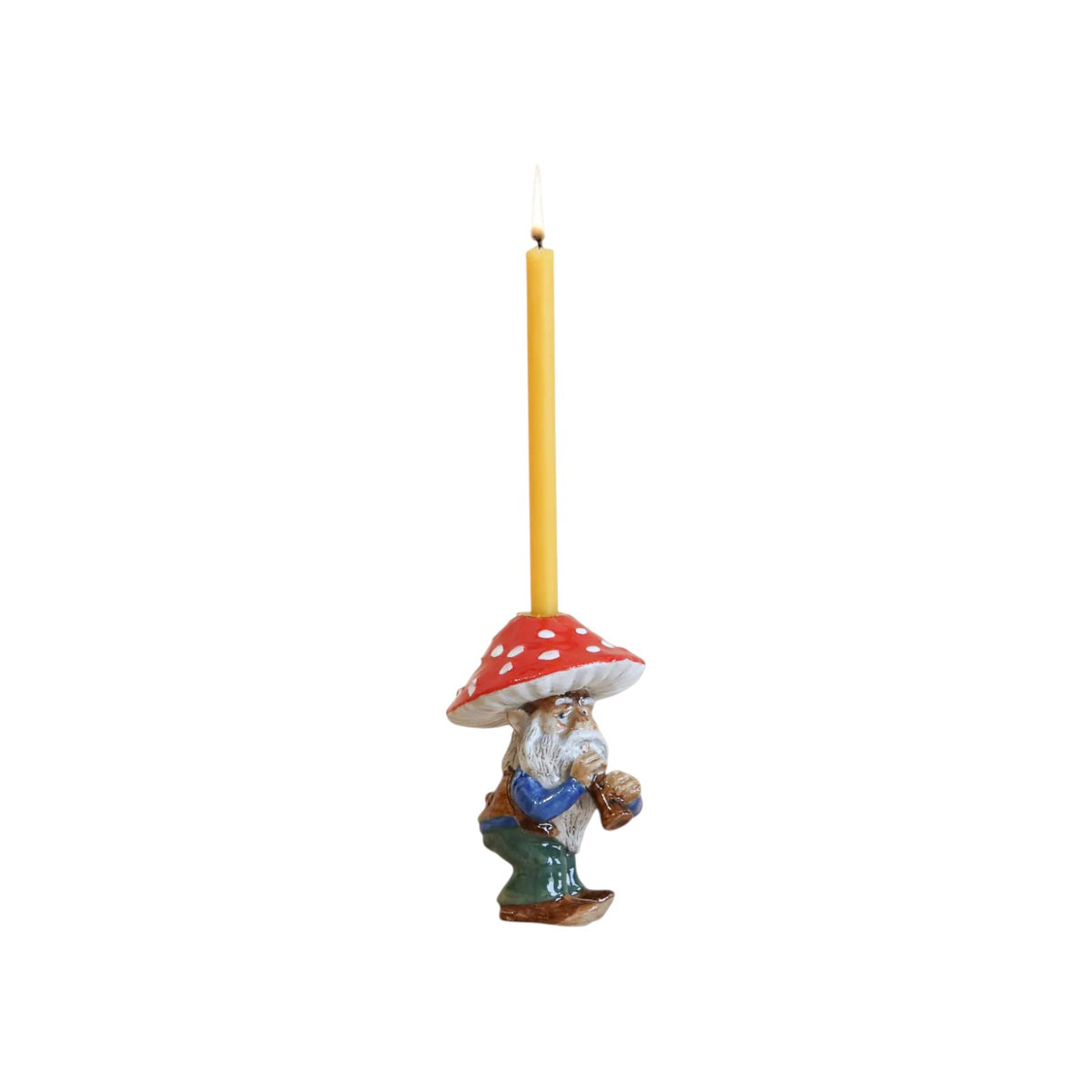 The Tiny Finch hand-painted ceramic mushroom gnome cake topper candle holder with a lit yellow taper candle
