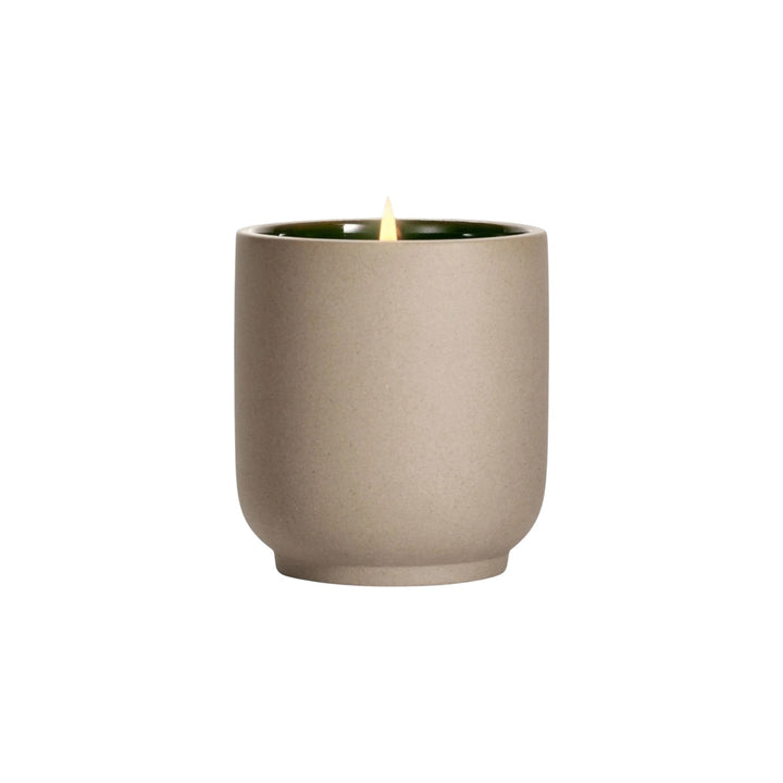 The Tiny Finch Neroli Leaf soy wax candle in a matte beige kiln-fired ceramic vessel with a green interior.