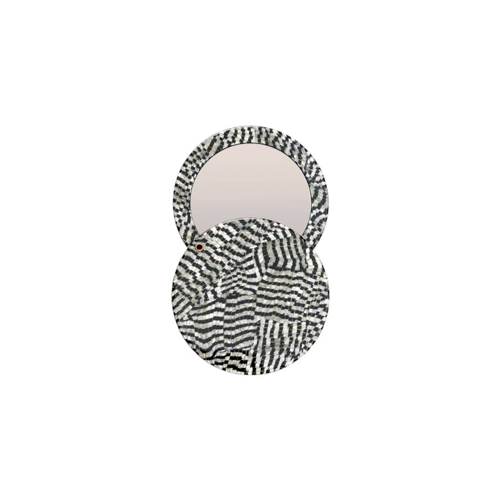 The Tiny Finch circular pocket mirror in Perle Noir featuring a black and white patterned Italian acetate swivel case.