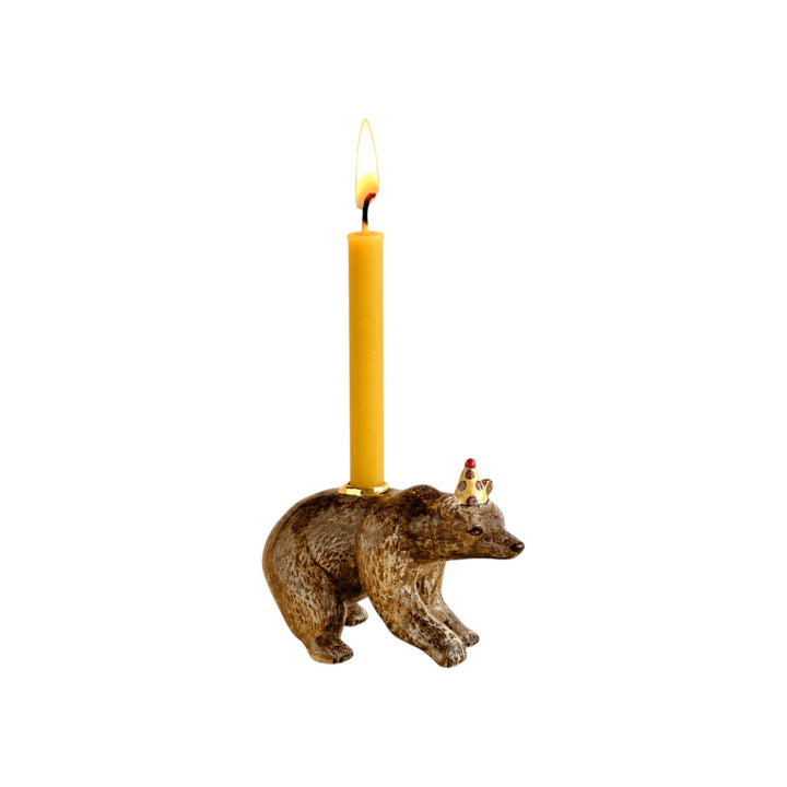 The Tiny Finch porcelain brown bear cake topper wearing a polka-dot party hat and holding a yellow birthday candle.