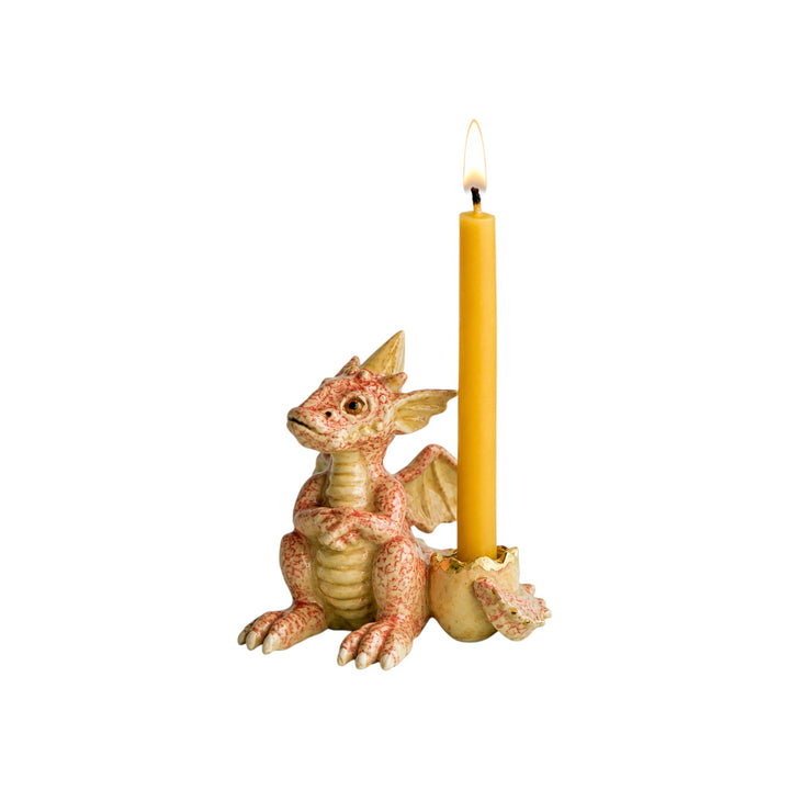 The Tiny Finch hand-painted porcelain dragon cake topper with a lit yellow taper candle in a cracked egg base.