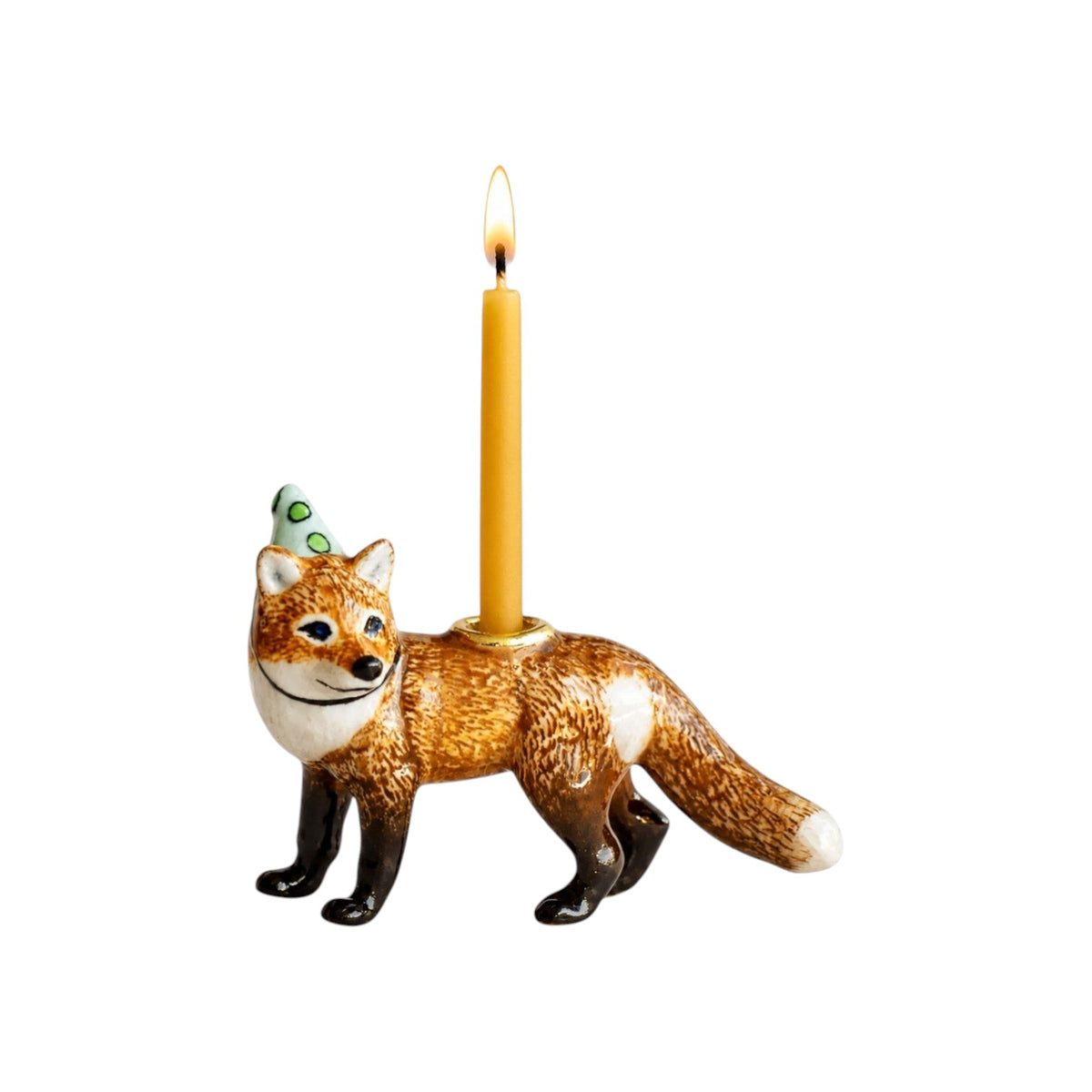 The Tiny Finch porcelain red fox cake topper wearing a green party hat with a lit birthday candle on its back.