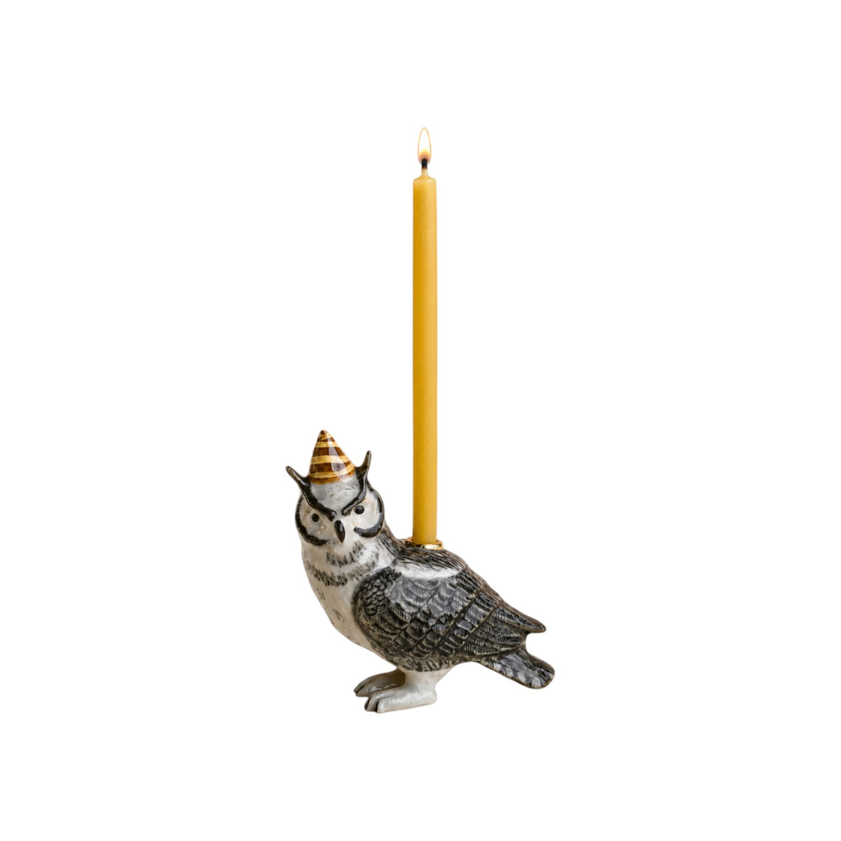 The Tiny Finch hand-painted porcelain wise owl cake topper wearing a party hat with a lit beeswax birthday candle.
