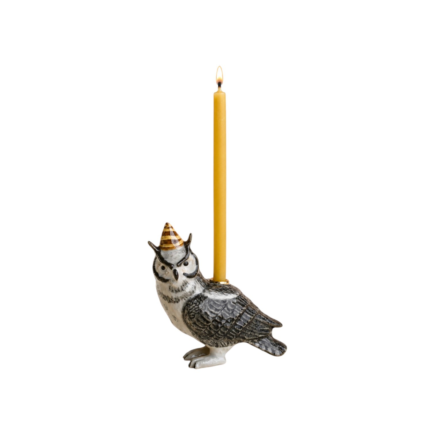 The Tiny Finch hand-painted porcelain wise owl cake topper wearing a party hat with a lit beeswax birthday candle.