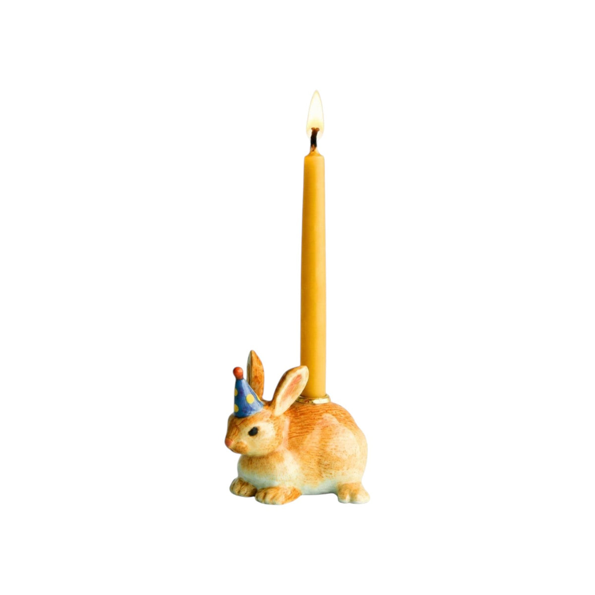 The Tiny Finch hand-painted porcelain rabbit cake topper wearing a blue party hat with a lit yellow birthday candle.