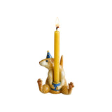 The Tiny Finch porcelain rat cake topper wearing a blue party hat and holding a lit yellow taper candle