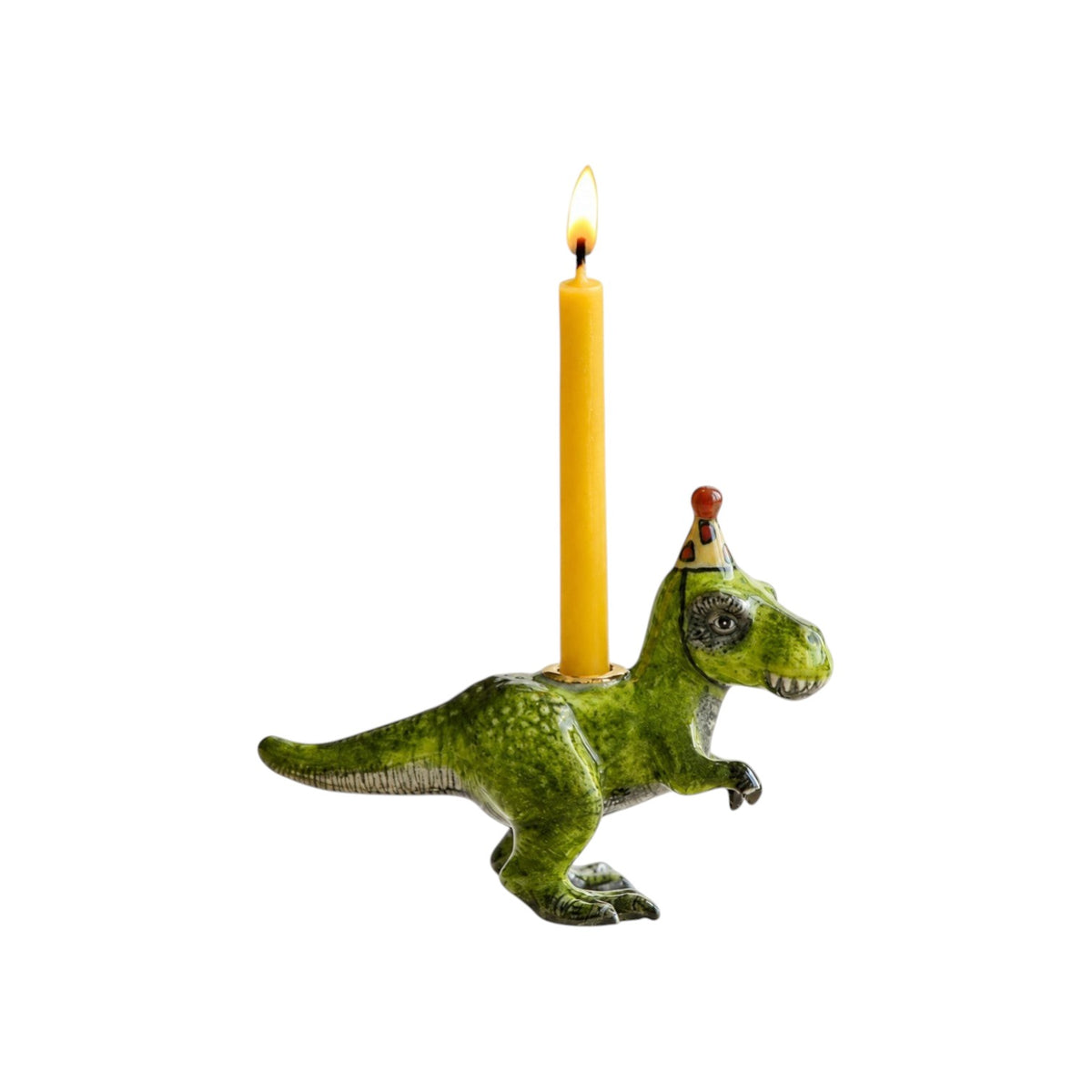 The Tiny Finch porcelain T-Rex cake topper wearing a party hat and holding a lit yellow birthday candle.