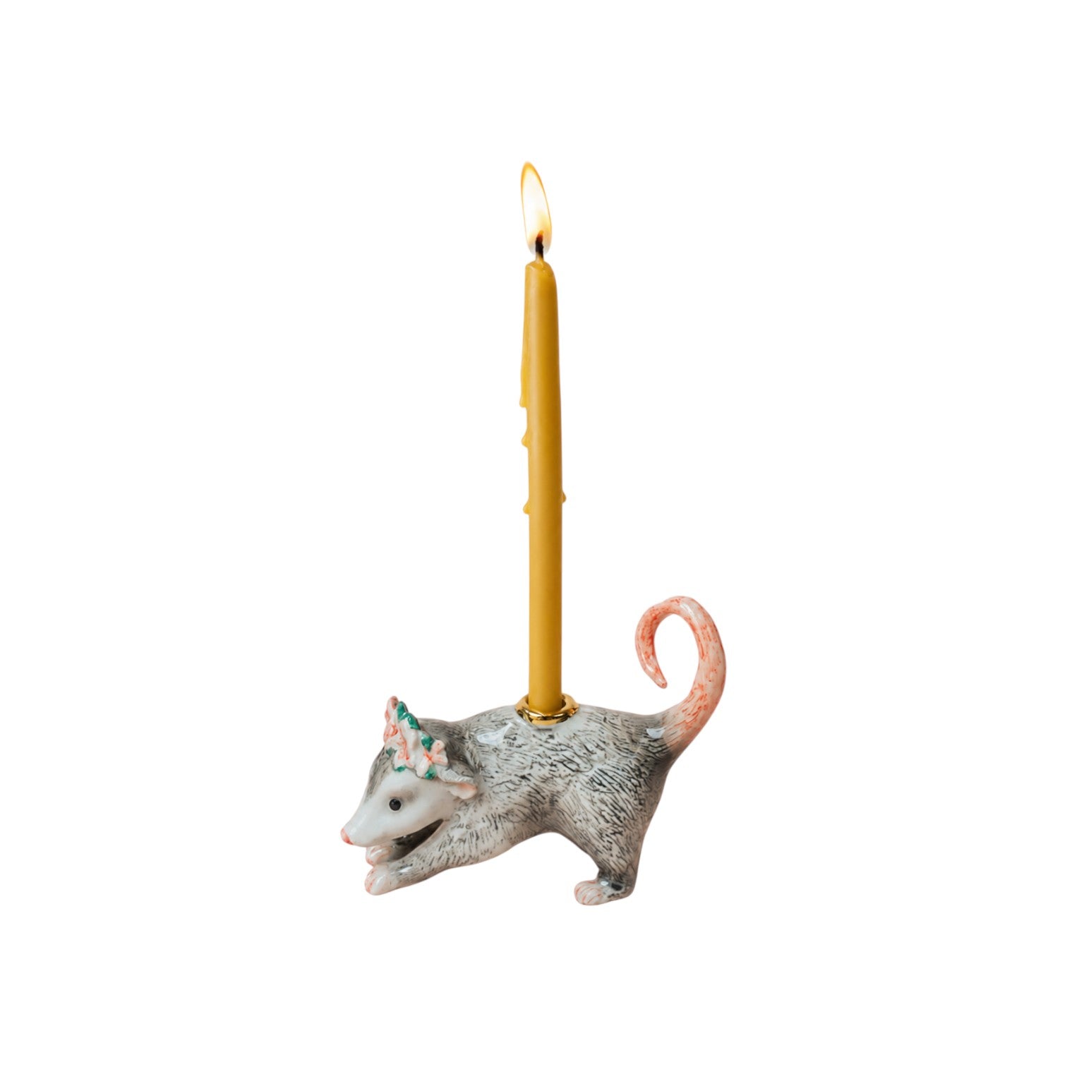 The Tiny Finch porcelain possum cake topper with a floral crown and a lit beeswax candle in a gold holder