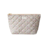 The Tiny Finch Juliette baby toiletry bag in quilted floral Liberty fleece fabric with a gold zipper closure.
