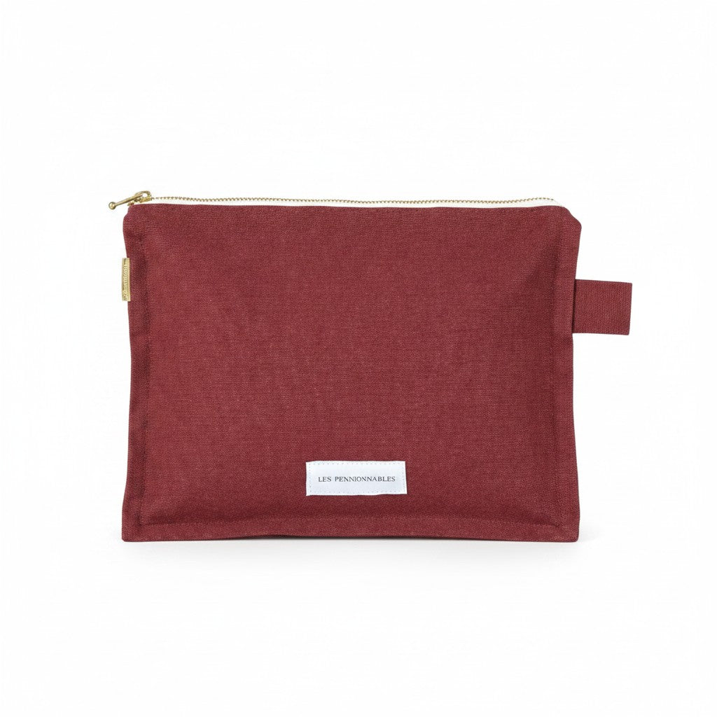 The Tiny Finch Les Pensionnaires rust organic cotton canvas toiletry bag with a gold zipper and side tab.