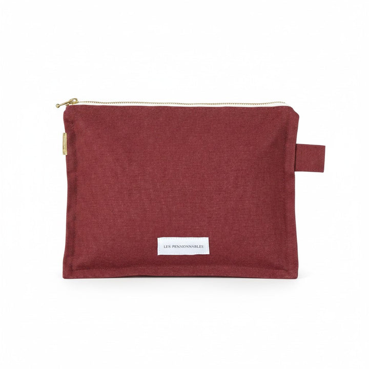 The Tiny Finch Les Pensionnaires rust organic cotton canvas toiletry bag with a gold zipper and side tab.