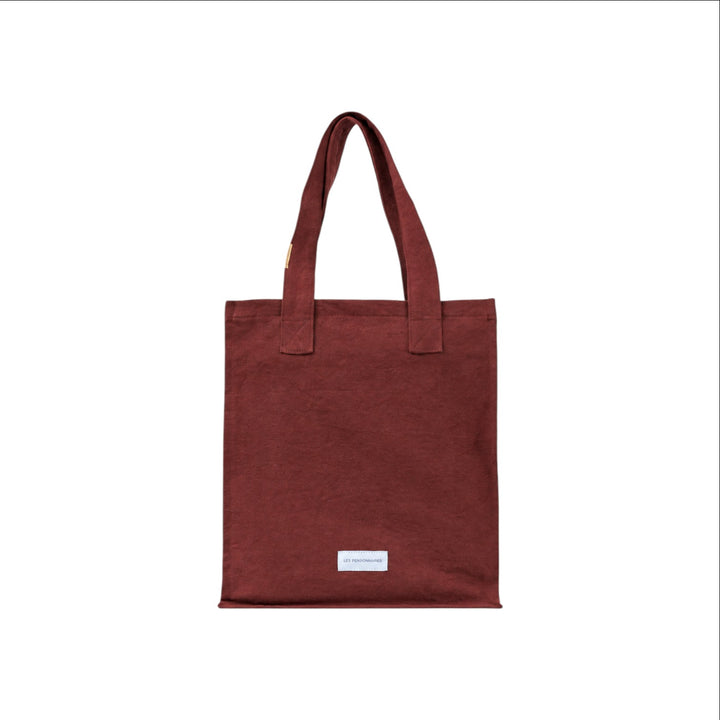 The Tiny Finch rust organic cotton canvas tote bag with a secure zip closure and minimalist label detail.