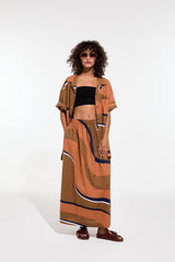 The Tiny Finch terracotta maxi skirt with wavy Madone print, elasticated waist, and side slits on a model.