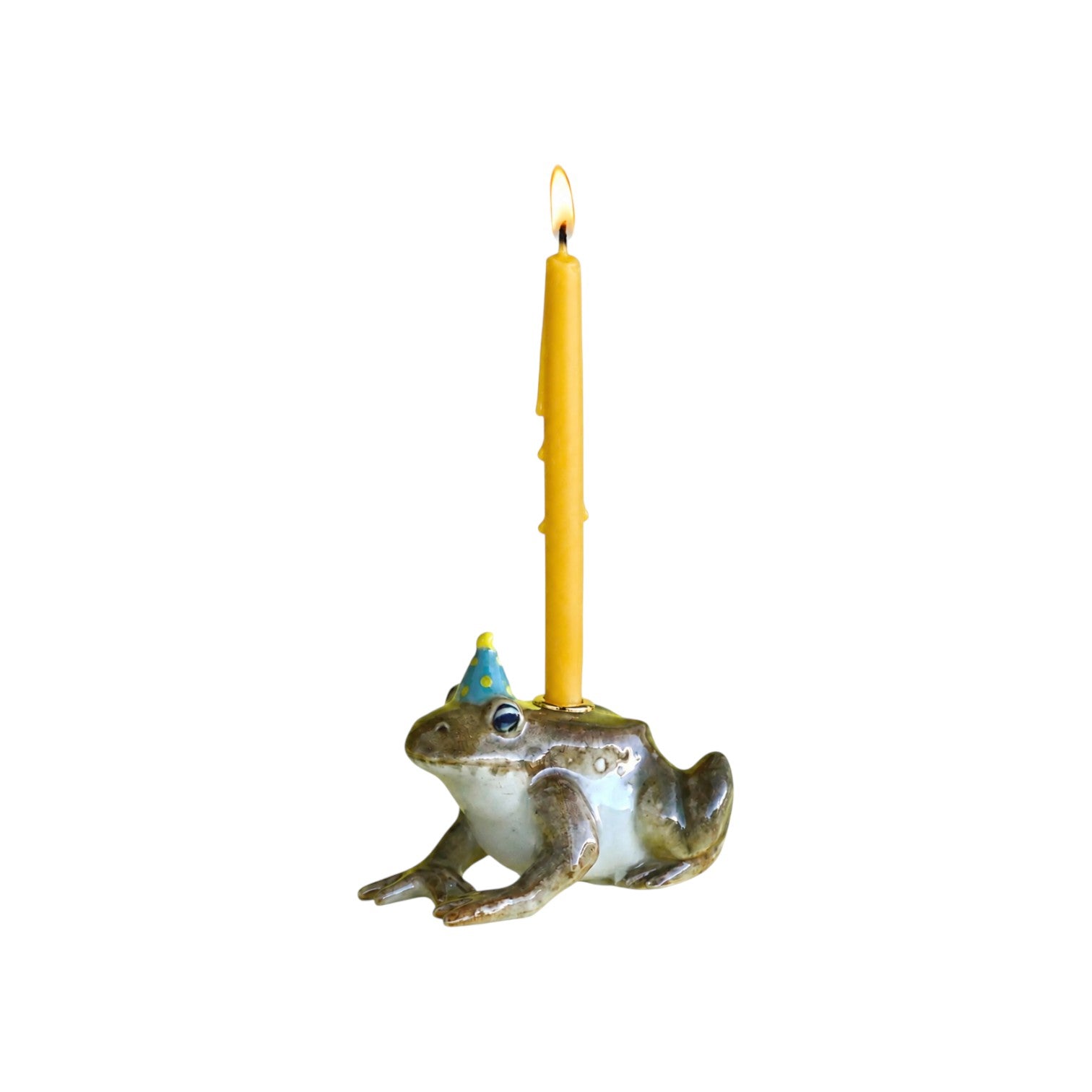 The Tiny Finch ceramic toad cake topper wearing a blue party hat with a yellow taper candle on a white background