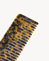 The Tiny Finch wide-tooth hair comb in classic tortoise shell pattern, handcrafted from Italian acetate.