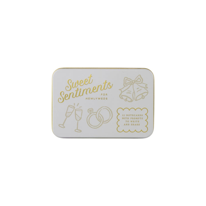 The Tiny Finch Sweet Sentiments keepsake tin with gold-pressed wedding illustrations and text on a white background.