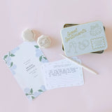 The Tiny Finch Sweet Sentiments wedding notecards in a gold-pressed tin with a bridal shower invitation and ring box.