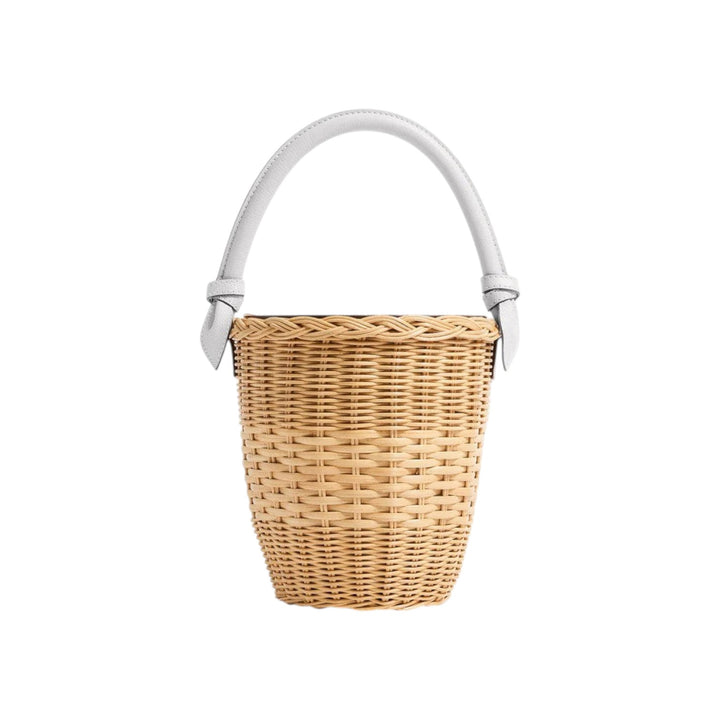 The Tiny Finch Jane Bag in white, a handwoven rattan basket bag with a lizard-embossed leather handle and closure.